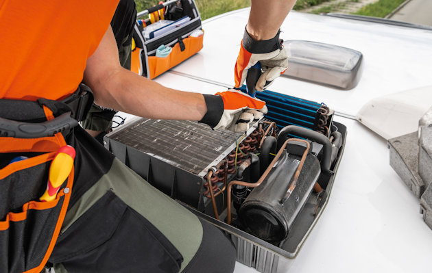 a man in an orange vest working on a car engine